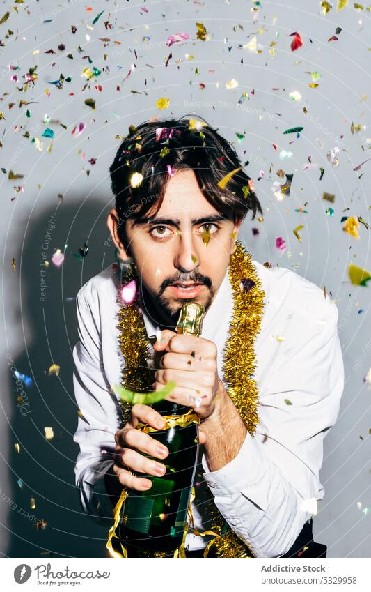 Drunk bearded man with bottle of champagne during Christmas holiday party christmas drunk microphone celebrate confetti portrait festive alcoholic concept