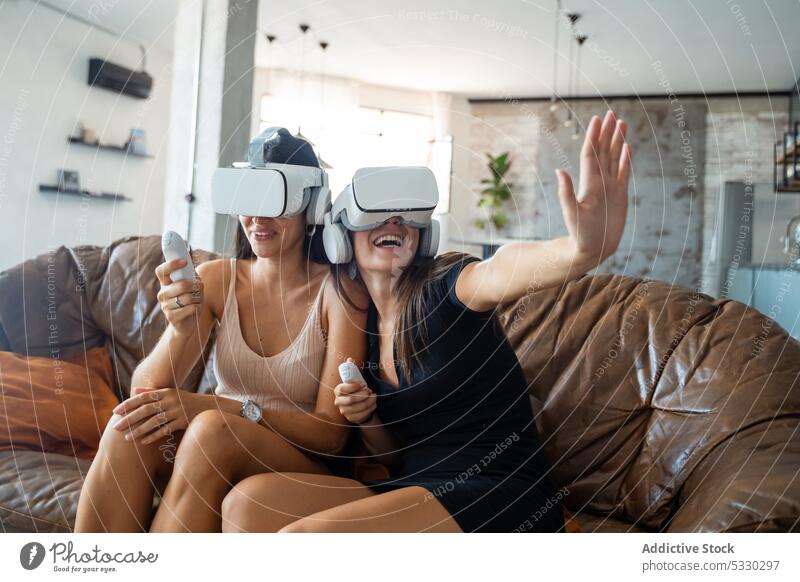 Excited women in VR headsets playing video game at home woman excited vr goggles friend fun virtual reality experience cheerful entertain interact innovation