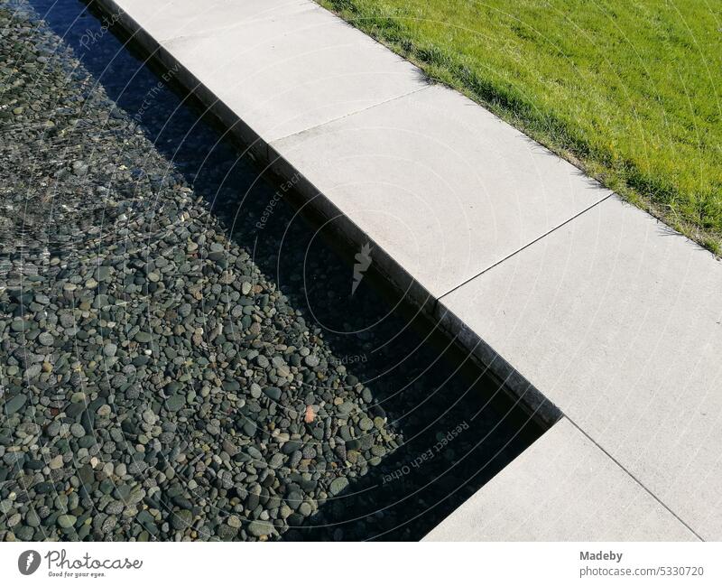 Modern bright edging of a gravel bed in the garden with light and shade in the sunshine in Stromberg near Oelde in the district of Warendorf in Münsterland in Westphalia