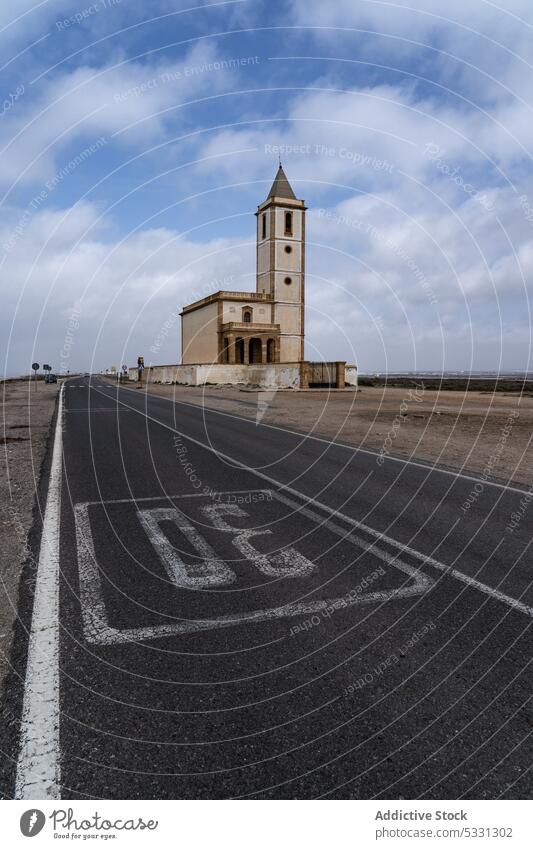 Old church on countryside road under cloudy blue sky sea exterior building architecture asphalt peaceful facade tranquil calm construction roadway scenic