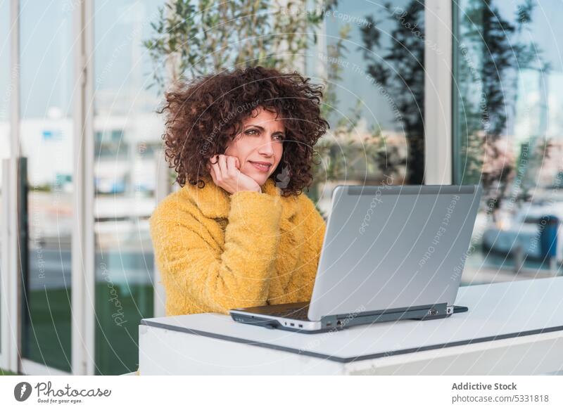 Woman typing on laptop in outdoor cafe woman using work freelance smile remote terrace happy browsing gadget device female project table keyboard computer young