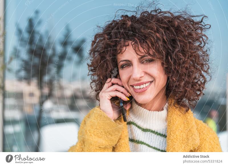 Delighted woman talking on mobile phone on street smartphone call smile positive speak communicate female casual gadget happy city cheerful using conversation