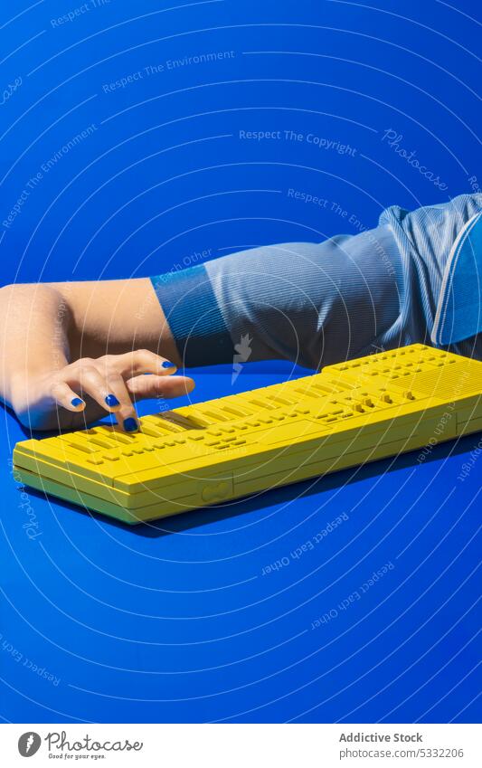 Crop woman playing yellow synthesizer keyboard hand piano music melody instrument sound electronic musician art entertain modern creative manicure nail polish