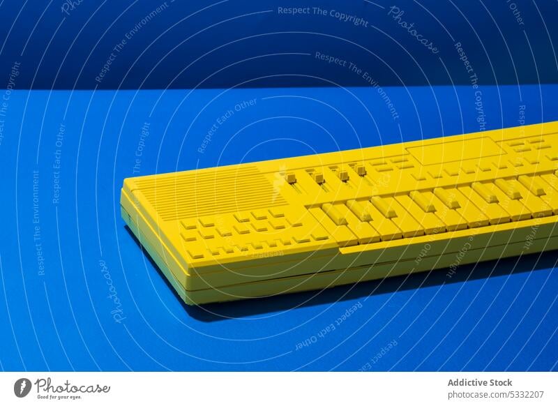 Yellow synthesizer keyboard on blue background button yellow piano instrument music modern electronic equipment bright device art new plastic audio electric