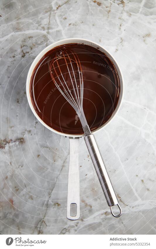 Melted chocolate in saucepan with whisk melt milk ganache sweet dessert mix ingredient process kitchen marble counter countertop food prepare tasty delicious