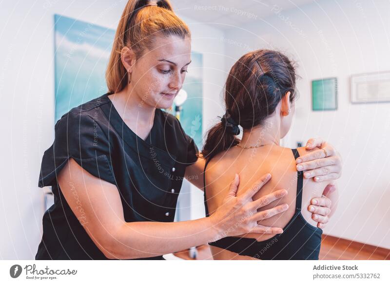 Osteopath massaging back of client in clinic women massage patient therapist osteopath masseur rehabilitation treat procedure specialist session doctor recovery