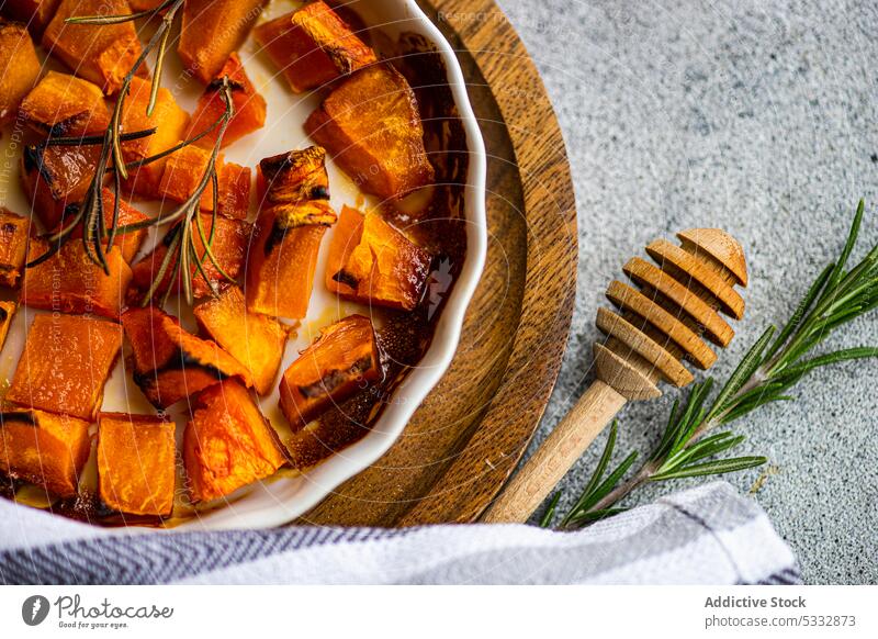 Sweet baked pumpkin cubes food board brown cook cooked cooking dish healthy herb herbs honey ingredient lunch meal organic pepper raw rosemary served set