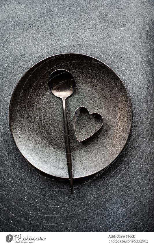 Minimalistic table setting in black color with spoon and heart background ceramic concrete cookie cutlery cutter dinner dinnerware eat eating food heart shaped