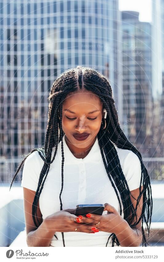 Cheerful black woman using smartphone on street cool smile browsing positive message happy surfing cellphone cheerful modern ethnic female african american