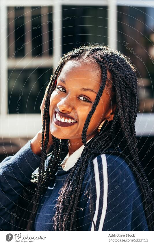 African American woman with Afro braids looking at camera dreadlocks appearance street portrait stare gaze happy positive hairstyle casual young female black