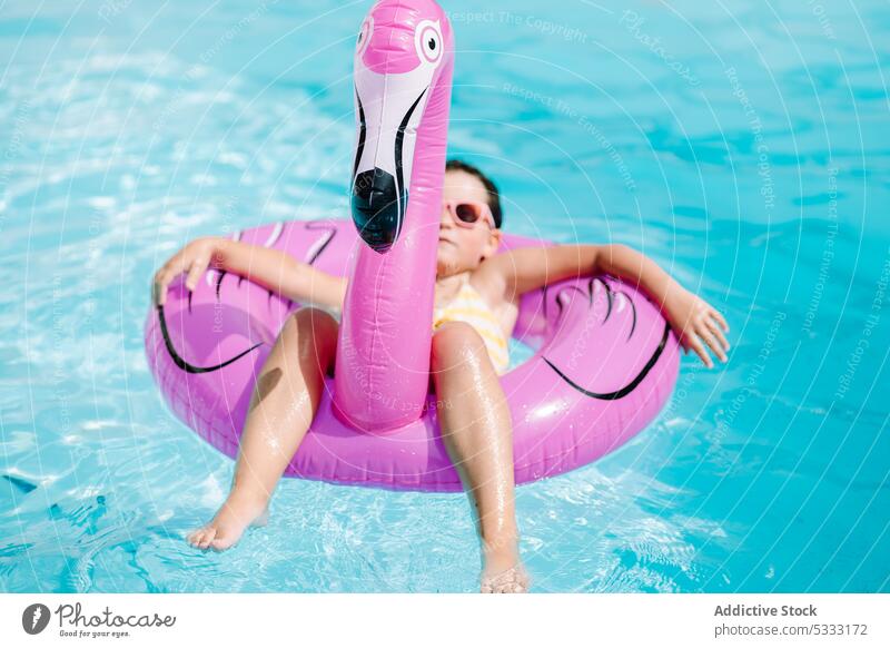 Little child resting in swimming pool girl water relax kid float inflatable summer holiday ring vacation resort tube swimsuit childhood swimwear happy pleasure