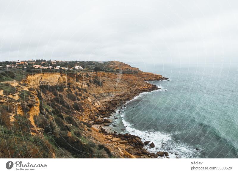 Mountainous coastline of Portugal's southern peninsula in the famous tourist region of the Algarve. The rocky cliffs around the town of Luz. Discovering the Fisherman trail, Rota Vicentina