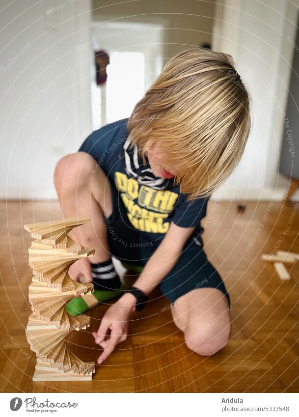 Child builds a wooden tower on the floor Build Playing Boy (child) Infancy Toys Brick Education Wood Construction pile Winding staircase spirally Living room