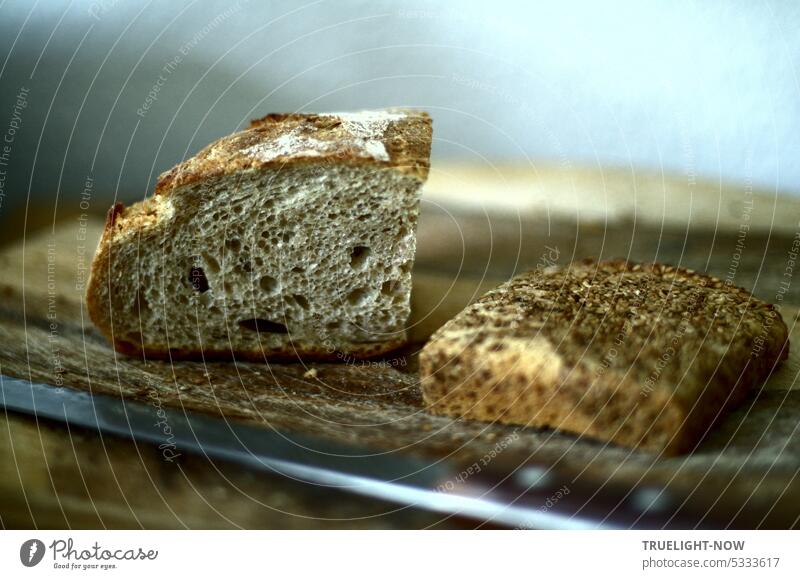 Two pieces of bread with long knife on wooden board, Bread Breads fresh bread Organic bread wholemeal bread ciabatta Italian French Country bread Spelt bread