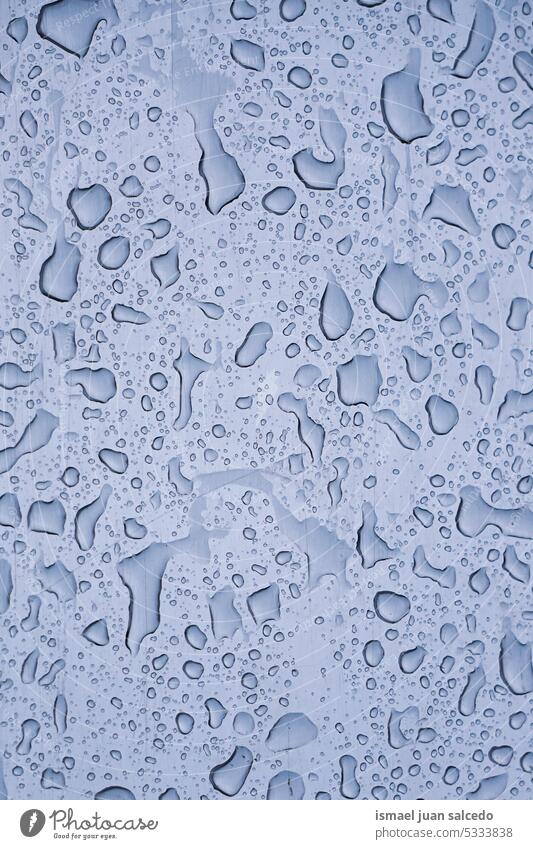 raindrops on the window in rainy days heart heart shape lover water wet glass gray grey blue transparent surface closeup abstract background textured bright