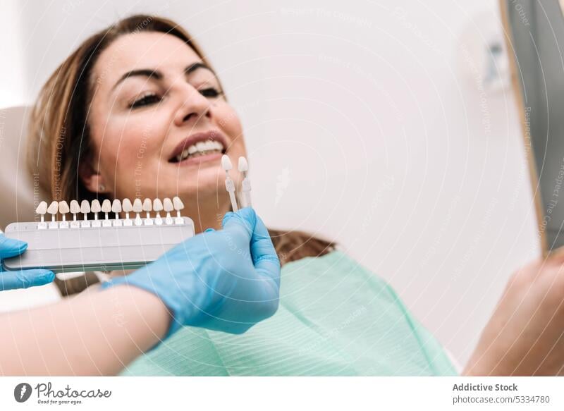Crop dentist showing dental veneers to patient teeth treat doctor stomatology work procedure woman specialist latex clinic oral demonstrate professional