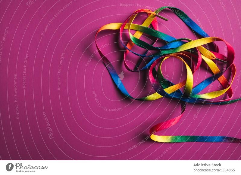 Multicolored vivid shoelaces on pink backdrop blocking design style fashion colorful spectrum wear strap bright multicolored vibrant unity mess yellow curve