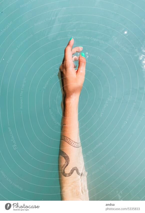 Tattooed arm in turquoise water Hand daintily Snake Nail polish Turquoise Water Woman Feminine Human being Day Fingers Skin Graceful