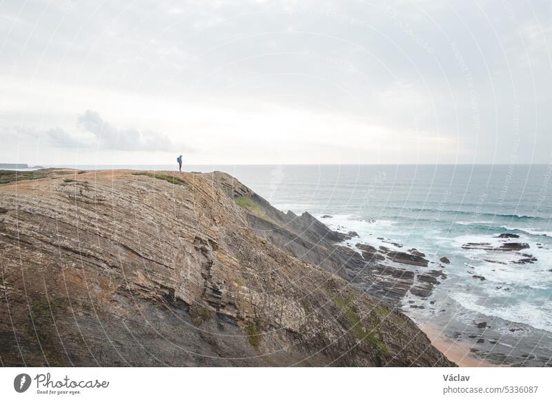 Travel enthusiast enjoys his freedom in the Portuguese countryside on the Atlantic coast observing the endless sea and the shapes of the cliffs. Wandering the Fisherman Trail