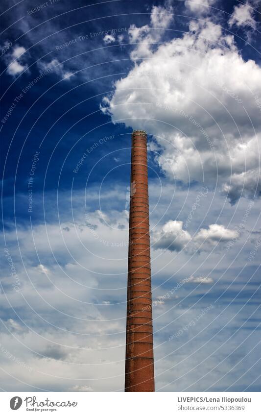 View of an ancient high chimney against the blue cloudy sky architecture artificial intelligence. sky backgrounds brick brown colour building built construction