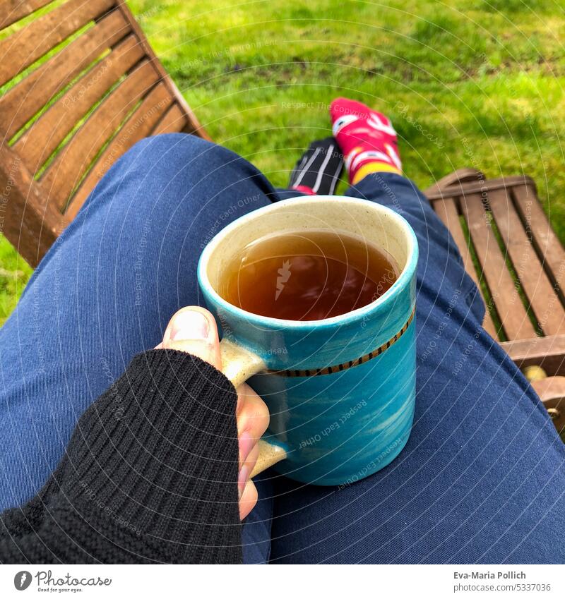 Tea cup in hand during time out in the garden with feet up Relaxation Hand Hot drink warming Cozy Woman Cup Fingers Young woman Beverage Food Healthy Lifestyle