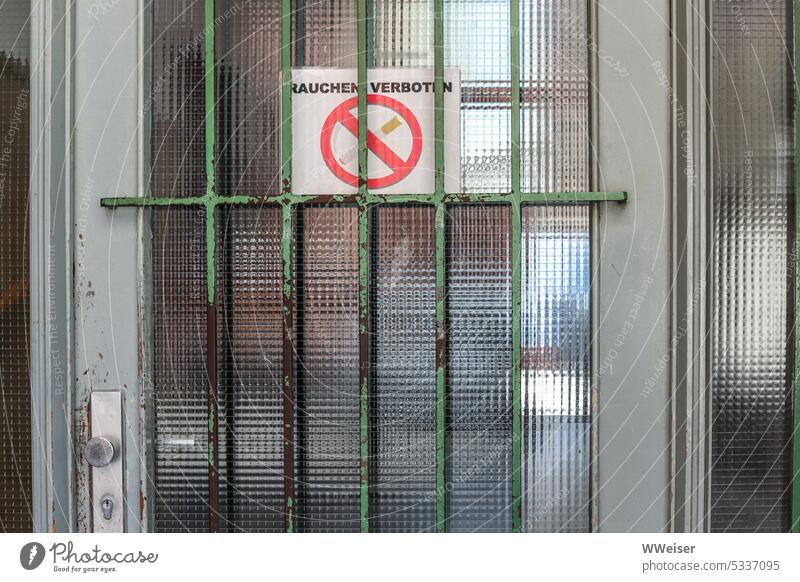 "No smoking" is written on the note stuck behind the grille of the front door smoking ban interdiction Smoking Prohibition sign Piece of paper Warn Front door