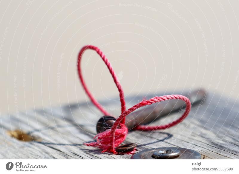 Plug bolt with red tape for identification lies on a wooden plank Socket pin kick the ball around Safety bolt Cotter pin Metal Steel Backup Band characteristics