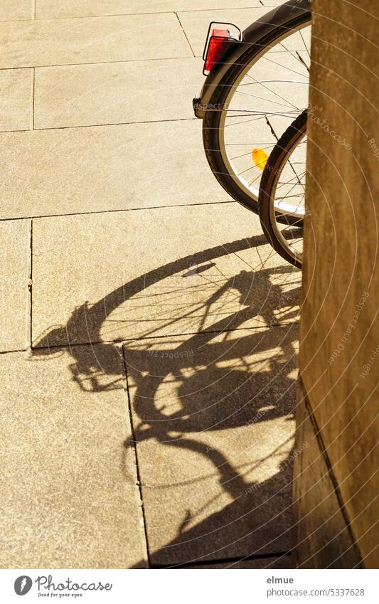 Partial shadow of two bicycles behind a wall Bicycle Wheel Ride a bike! Shadow play Wall (building) Blog alternative means of transportation Cycling