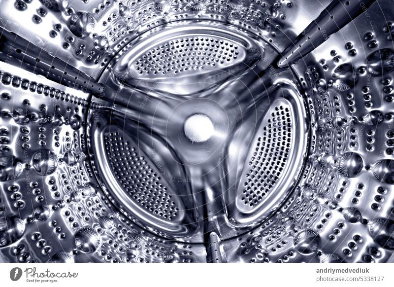 Inside of a shine steel drum of the washing or dryer machine. Laundry day. Daily household chores. Domestic and household appliance. Home innovation. clean
