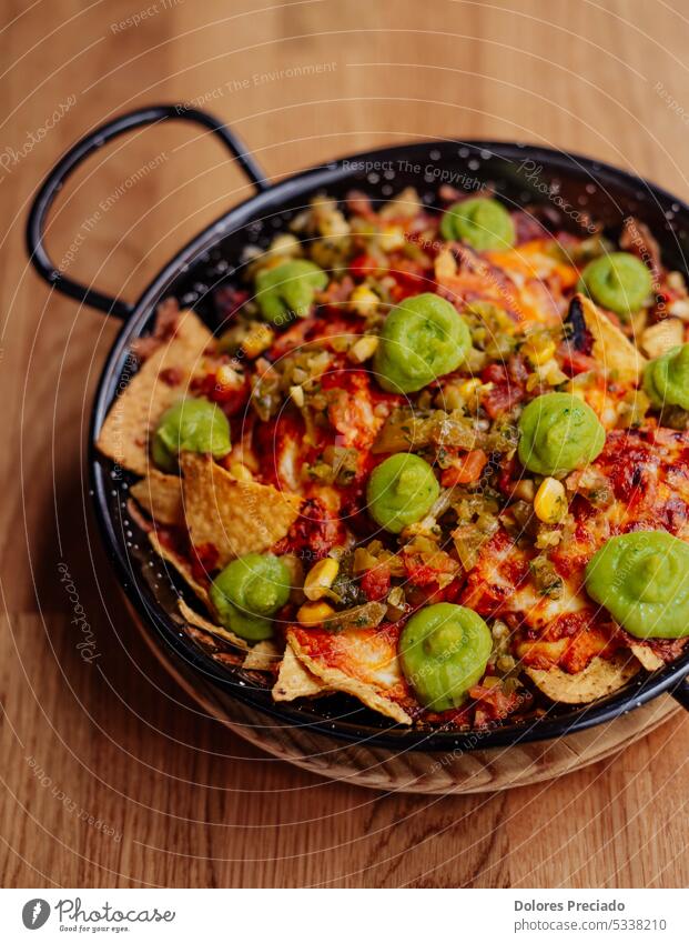 Plate of nachos with meat, cheese and guacamole appetizer avocado background beer cheddar chili chip chipotle pepper corn corn chips cream crunchy cuisine