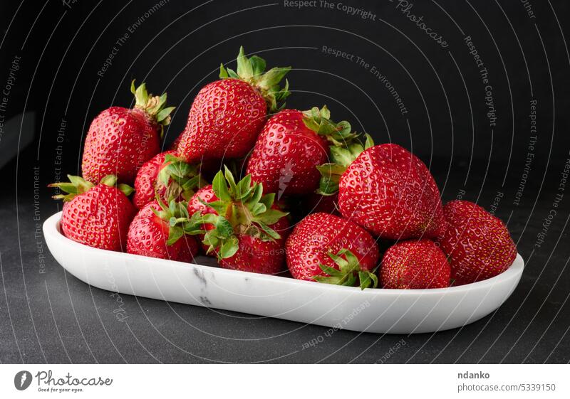 Ripe red strawberries on a black table strawberry group whole ripe fruit food fresh diet juicy freshness sweet harvest nobody