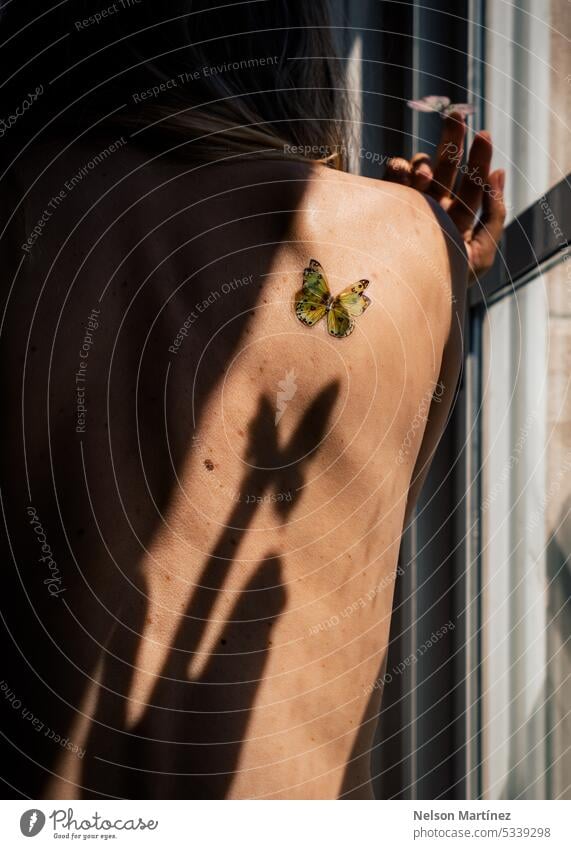 Close up of woman's skin texture with moles and butterfly body shadows beautiful nude empowerment alone isolated strong young contrast innocence natural healthy