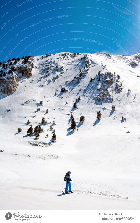 Unrecognizable skier riding ski on snowy mountain ride winter slope activity sport extreme nature cold season frost enjoy trip journey frozen traveler