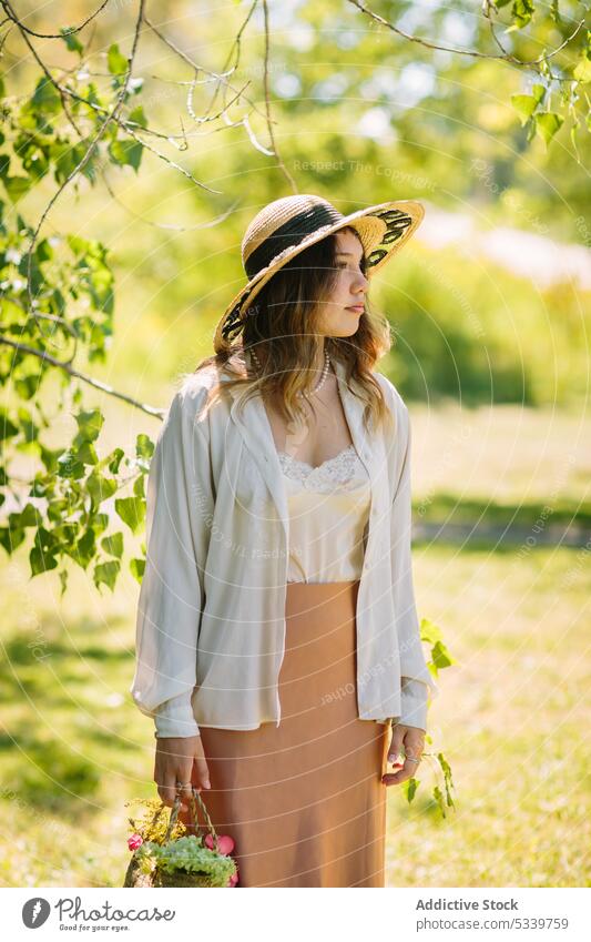 Charming woman with wicker basket walking in park flower pensive nature flora bouquet summer female countryside straw hat fresh young daytime garden calm style