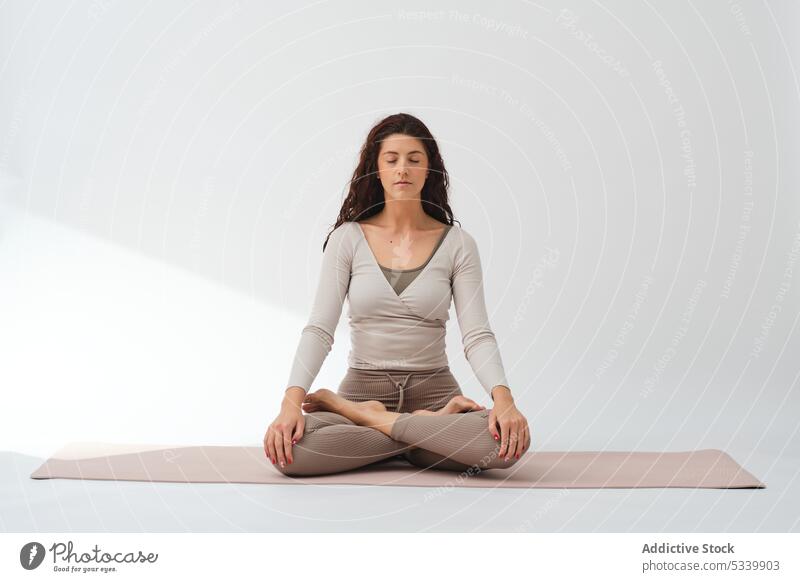 Woman meditating with lotus pose and Namaste hands woman yoga padmasana meditate practice barefoot mindfulness wellness concentrate studio zen healthy mat calm
