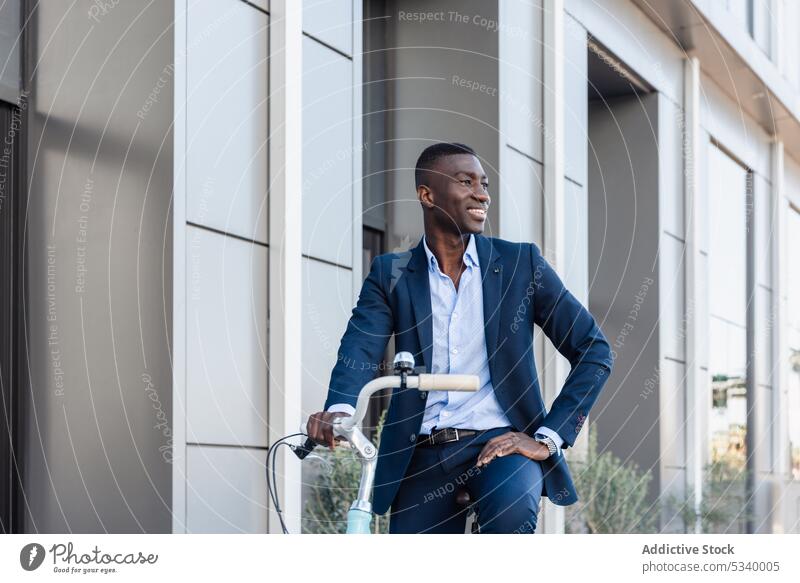 Happy black businessman riding bicycle in street ride entrepreneur work smile cheerful happy positive building african american male well dressed ethnic bike