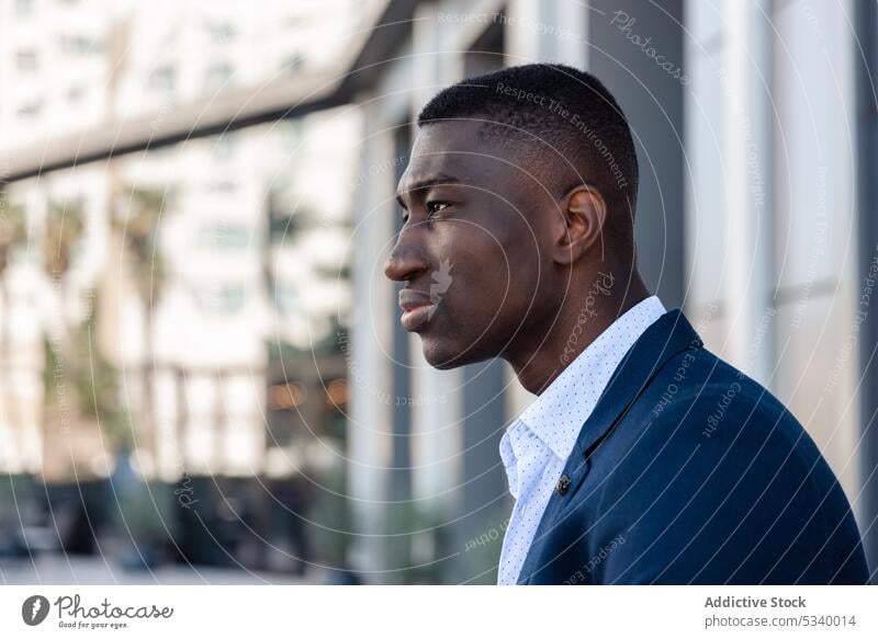 Black man in suit looking away businessman entrepreneur happy employee serious work street worker reflection glass wall well dressed formal office executive