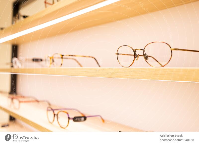 Eyeglasses on illuminated shelves in shop eyewear store optical shelf style contemporary design modern collection light frame retail interior detail creative