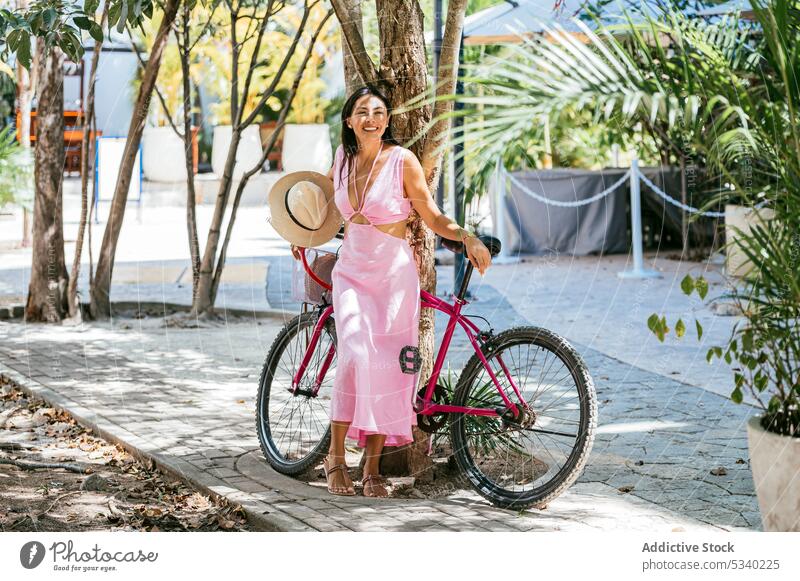 Cheerful woman with bicycle on street summer positive city style happy smile bike young female tulum mexico mexican asian japanese dress mixed race cheerful