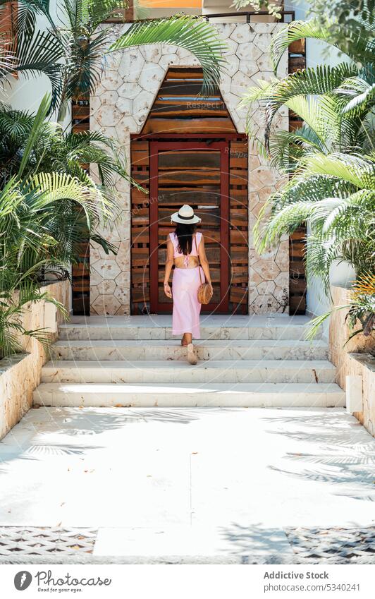 back view woman going downstairs in tropical park tourist resort garden building vacation thoughtful summer style travel walk female mexican mexico japanese