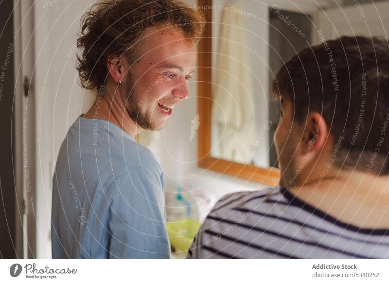 Happy men looking at each other and laughing at home bathroom friend positive routine together morning happy smile cheerful young friendship domestic hygiene