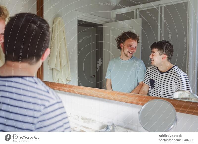 Happy men looking at each other and laughing at home bathroom friend positive routine together morning happy smile cheerful young friendship domestic hygiene