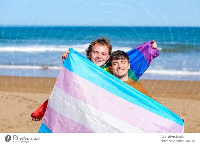 Content gay couple resting on sandy beach men partner lgbt flag holiday celebrate sea male lgbtq homosexual transsexual transgender androgynous queer equal