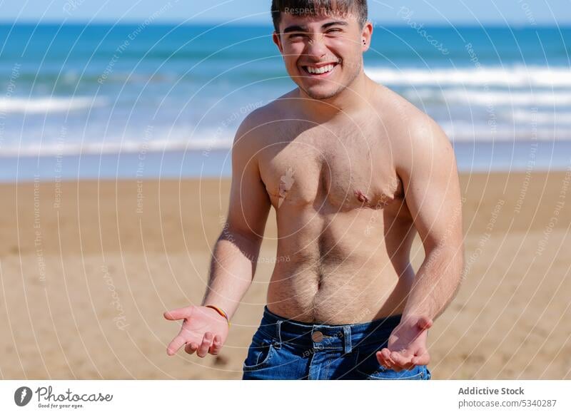 Glad shirtless gay on beach man transgender sunbath sand sea topless smile male lgbt lgbtq homosexual transsexual androgynous queer cheerful pride equal rights
