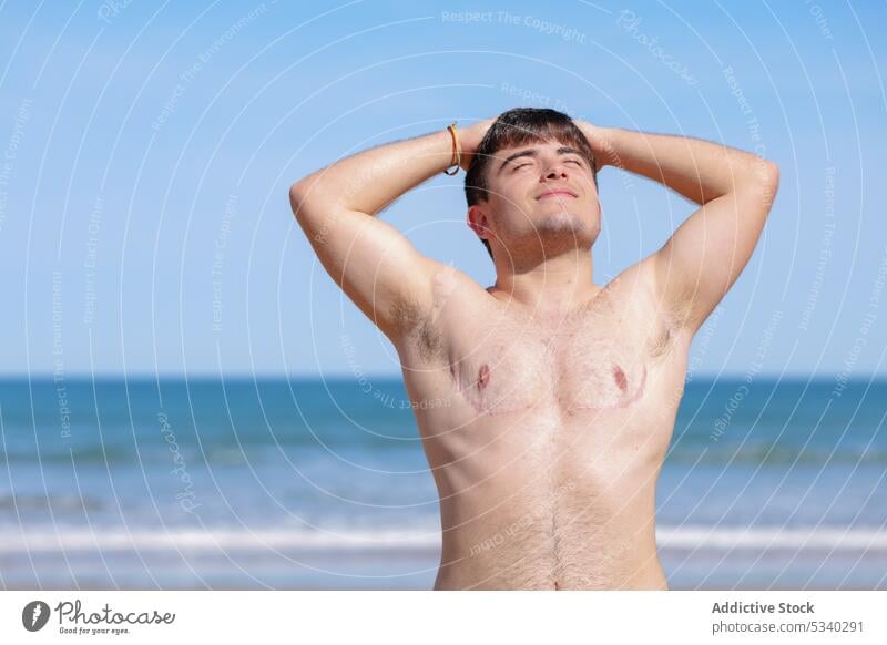 Glad shirtless gay on beach man transgender sunbath sand sea topless male lgbt lgbtq homosexual transsexual androgynous queer pride equal rights tolerance