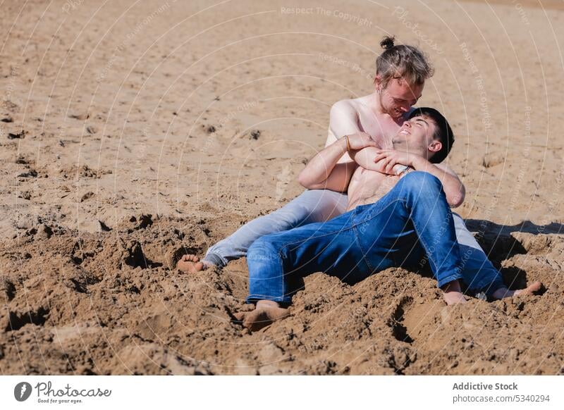 Content shirtless gay couple hugging on beach men partner embrace summer weekend romantic male lgbt lgbtq homosexual pride transgender transsexual androgynous