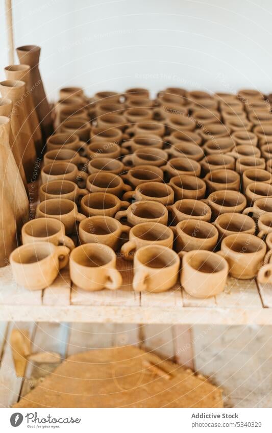 Unfinished clay cups on wooden table vase workshop handmade unfinished creative handicraft professional pottery ceramic collection art shape earthenware set row