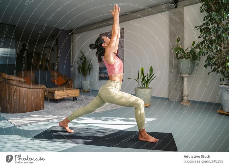 Slim woman performing Crescent Lunge pose on mat yoga asana crescent lunge mindfulness stretch practice balance activewear healthy ashta chandrasana flexible