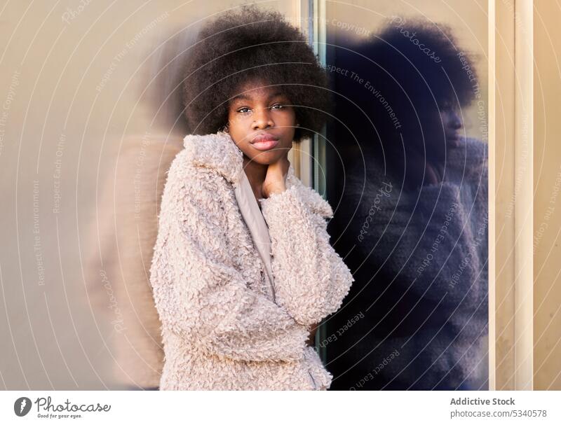 African American teen in trendy cozy outfit afro cheerful metallic wall glass wall reflection mirror african american black female hairstyle ethnic appearance