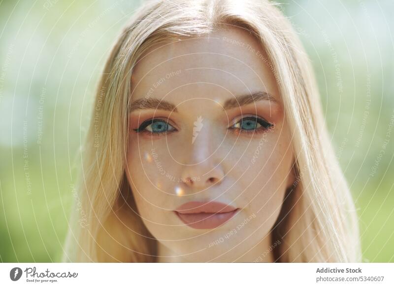 Young blond woman outdoors with sunlight spots on her face Woman female young young adult adolescence youth sunshine sunny shiny looking at camera close-up